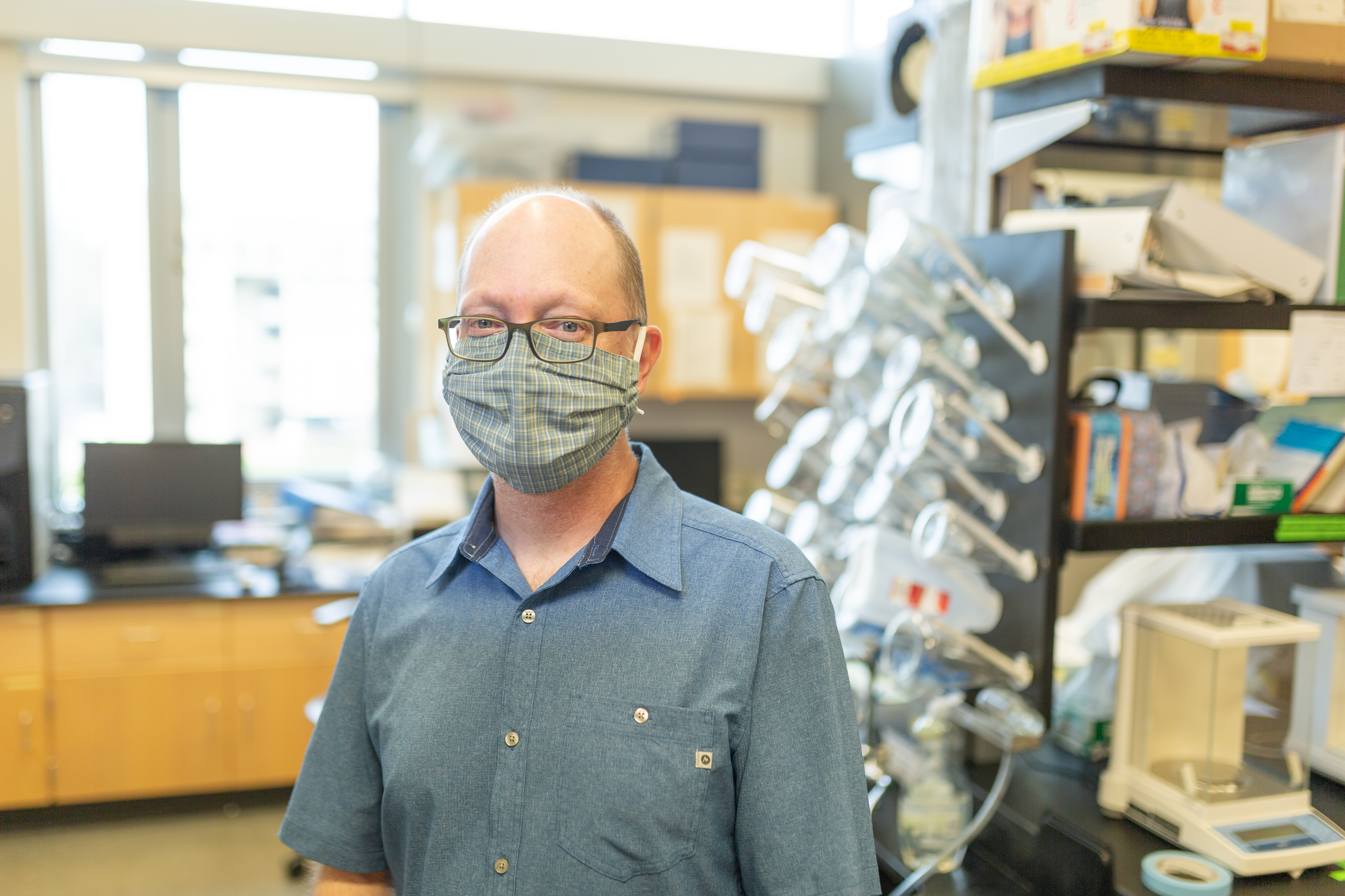 Professor Jeff Grimm, wearing a mask, in his laboratory