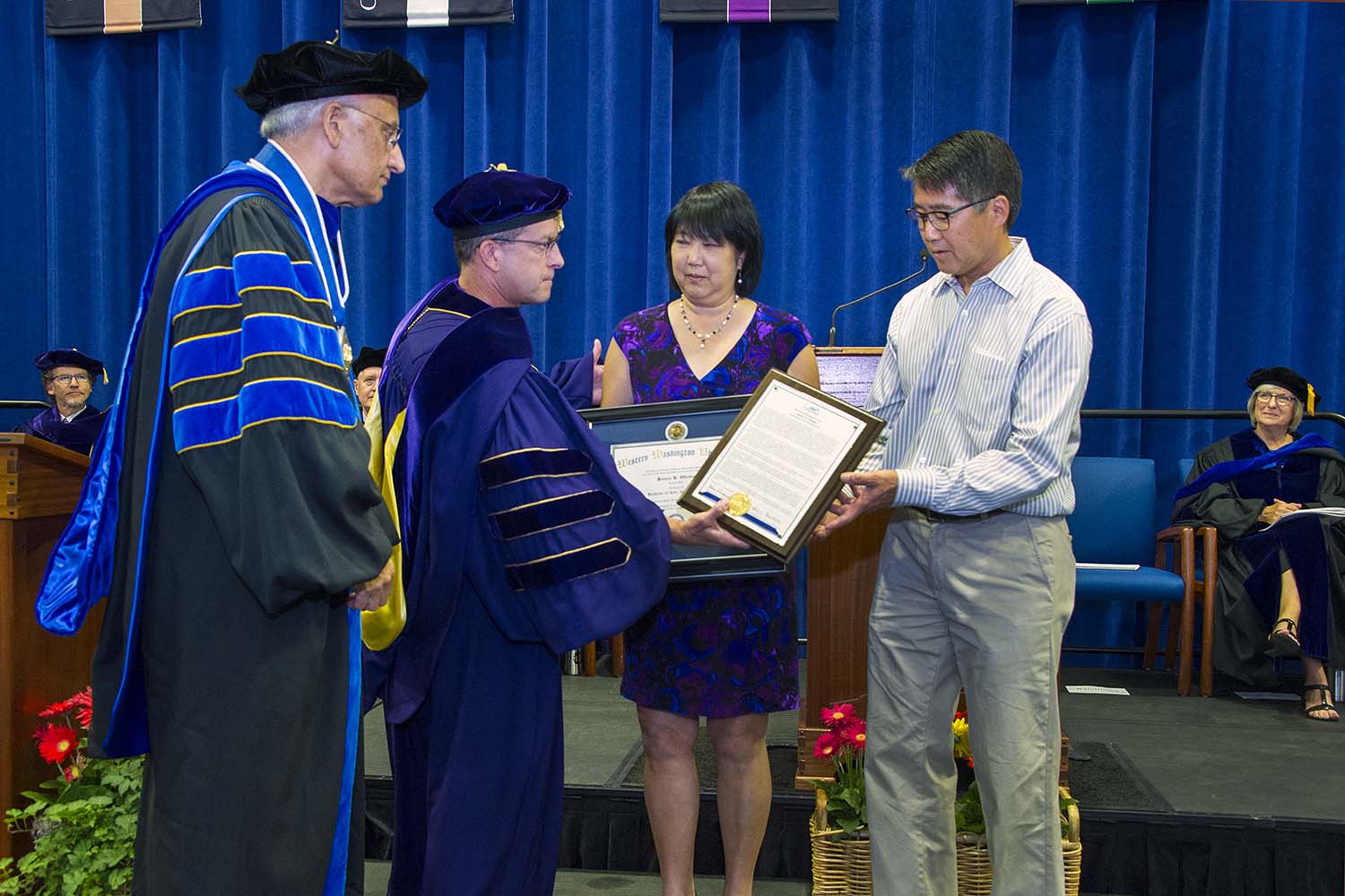 President Sabah Randhawa and Provost Brent Carbajal present an honorary bachelor’s degree to James Okubo’s children Anne and Bill Okubo at Commencement in June.  