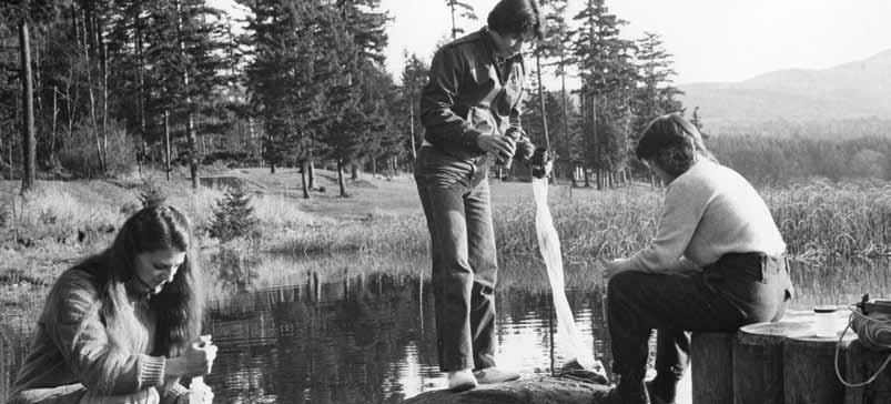 A 1986 photo of students taking water samples along a lake shore