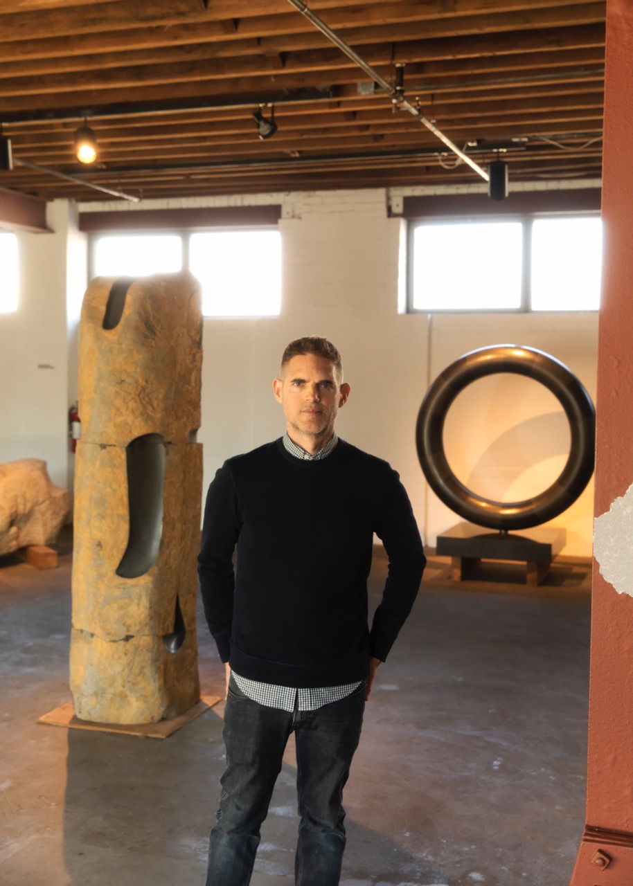 Dakin Hart stands among sculptures in a gallery