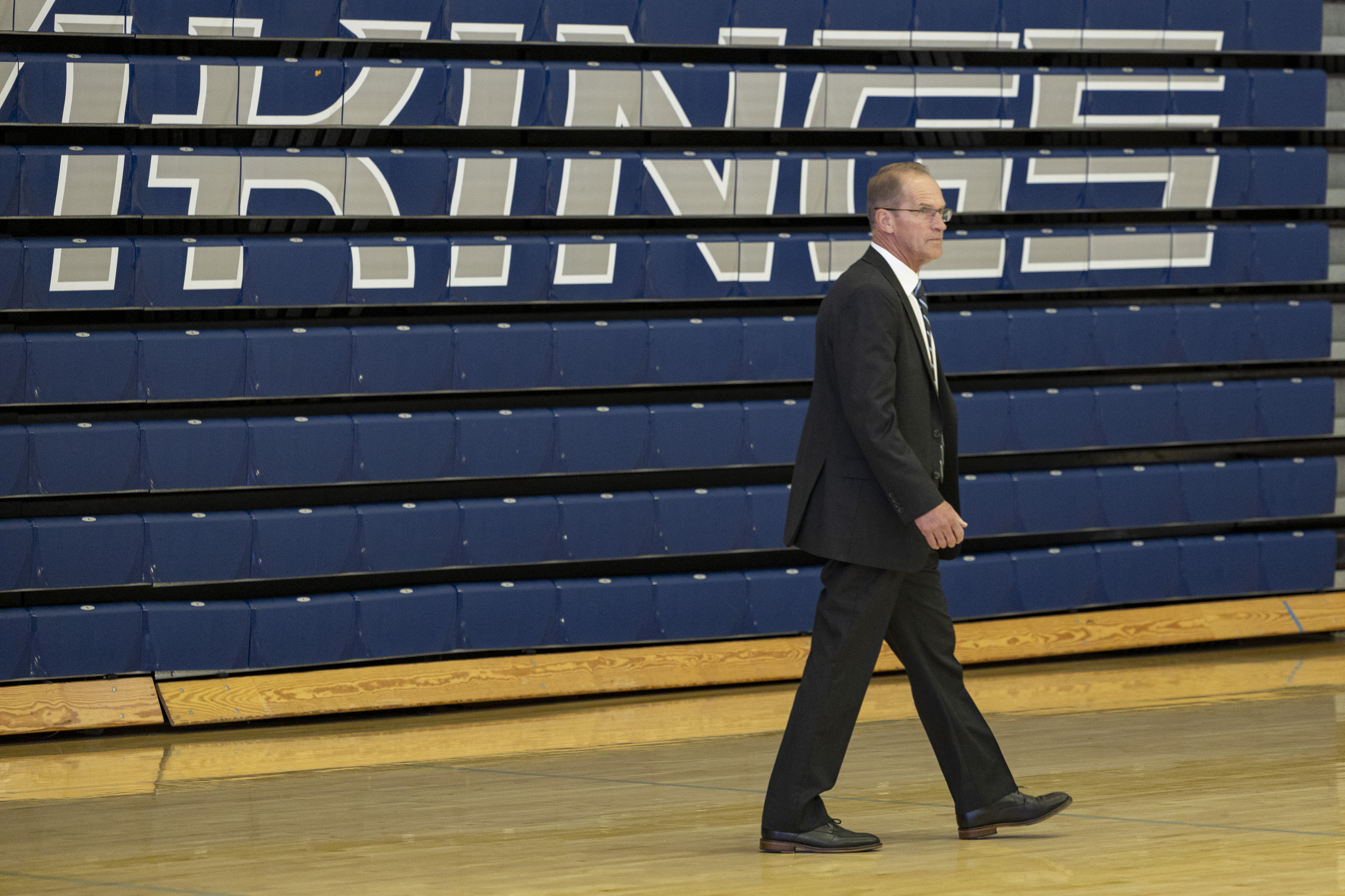 Sterk walks by the closed bleachers in Carver, which have the word 'vikings' painted on them