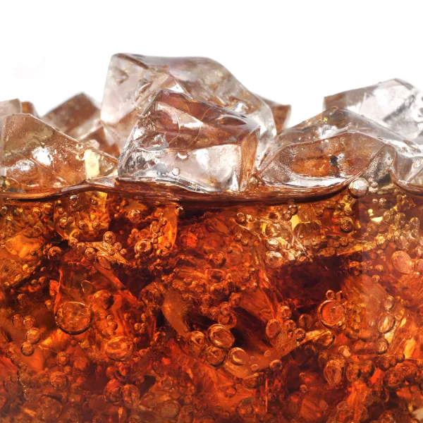 photograph of ice cubes floating in fizzy cola