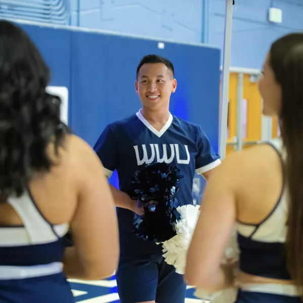 Ethan Huynh in a cheerleading uniform on the basketball court