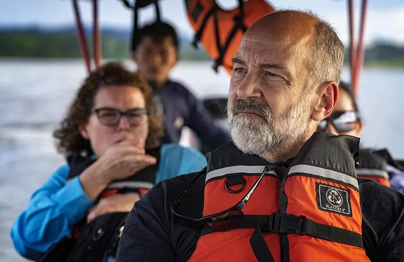 Story author John Thompson wearing a life jacket in the front of a boat, looking out onto the water