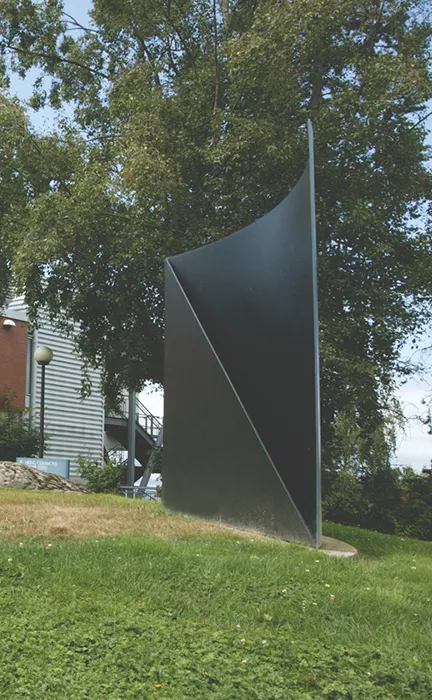 Maki's Curve/Diagonal sculpture, a black matte metal curved plane fronted by flat triangle-shaped piece