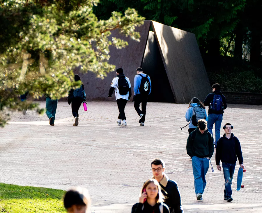students walk past Wright's Triangle on a sunny day