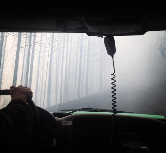 a view out a truck windshield through the smoky haze